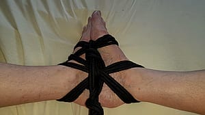 Feet tied with black rope'